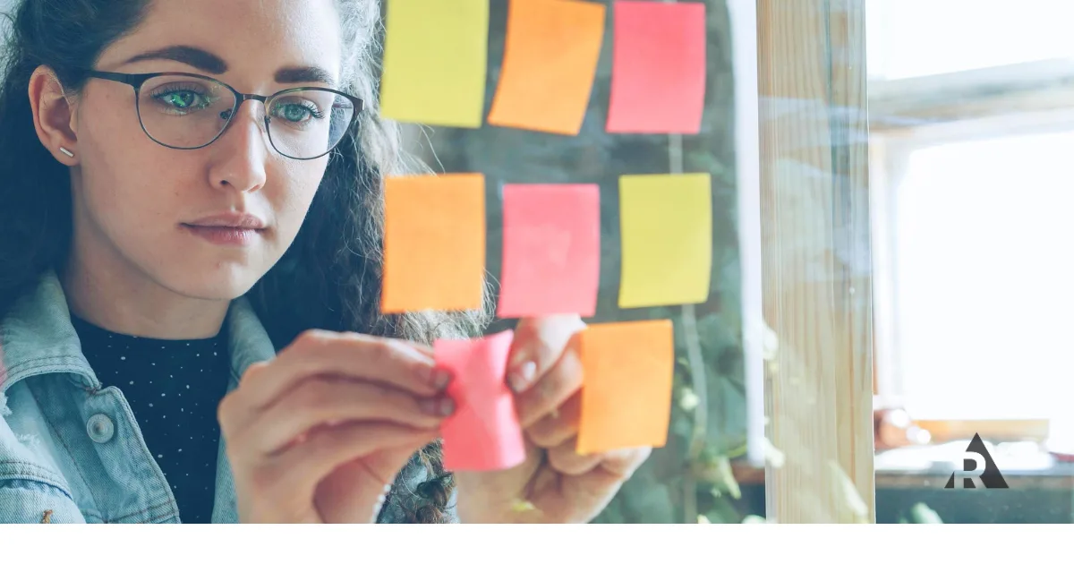 Women putting sticky notes on board