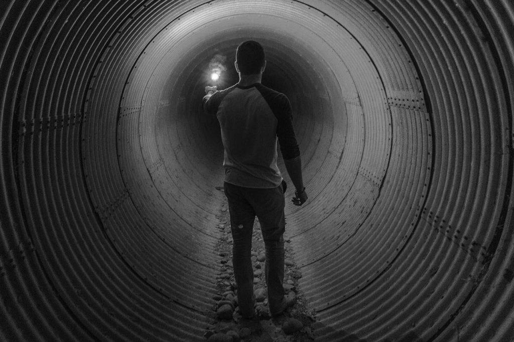 What must management do for a successful agile transformation - a person leading the way through a dark tunnel