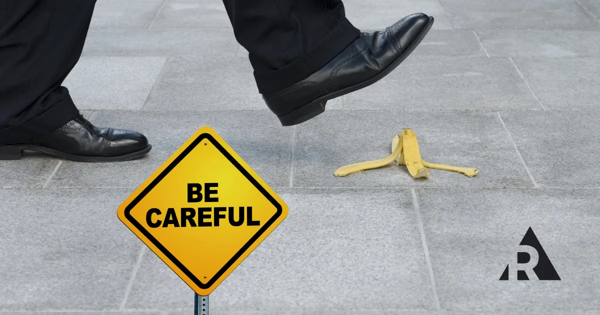 Man slipping on a banana peel with a be carful sign